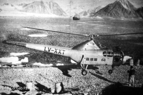 El S-51 LV-XXT operando sobre suelo antártico mas al fondo del ARA Bahía Aguirre
